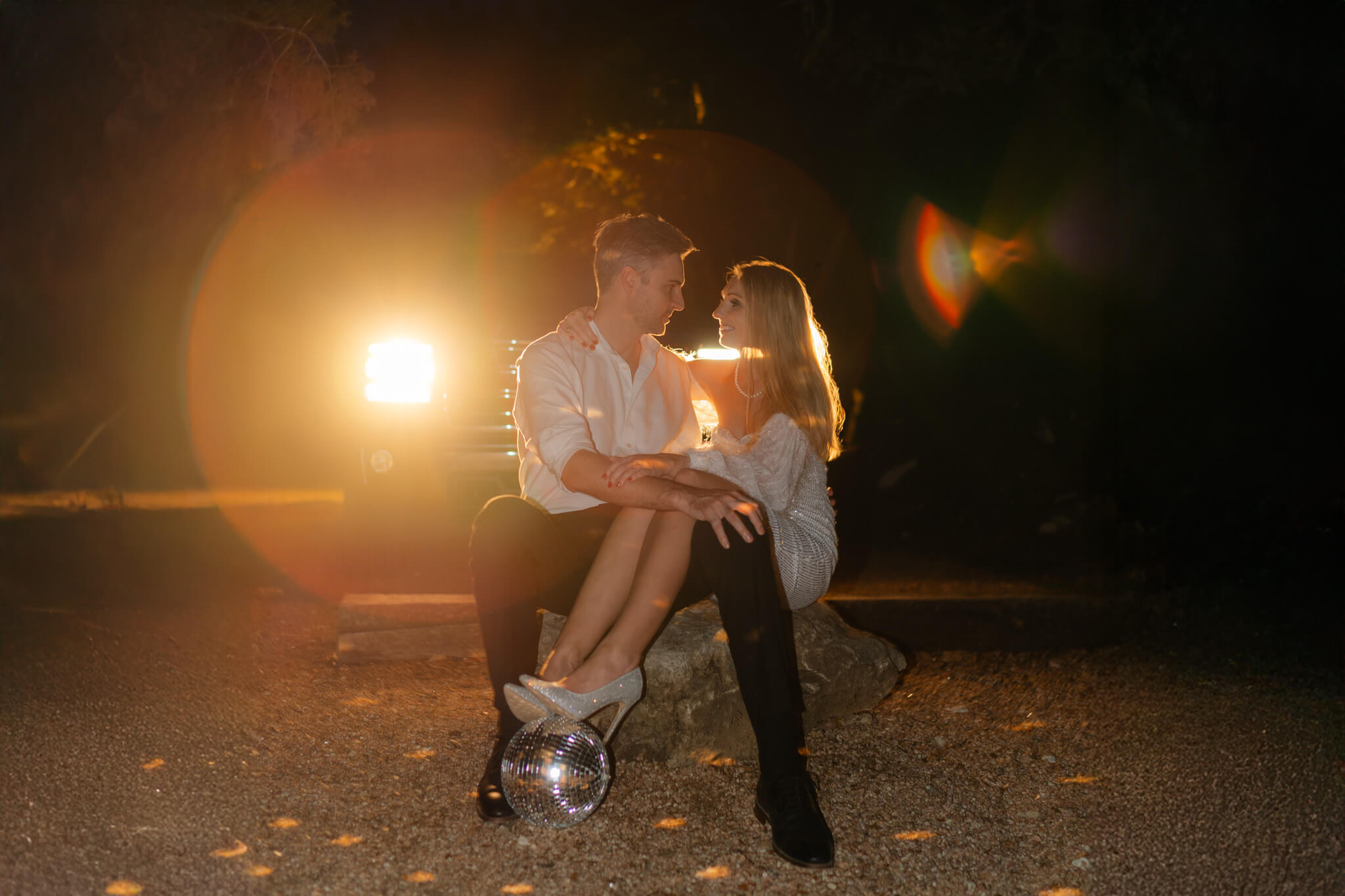 bride and groom in front of headlights at their lucky arrow elopement