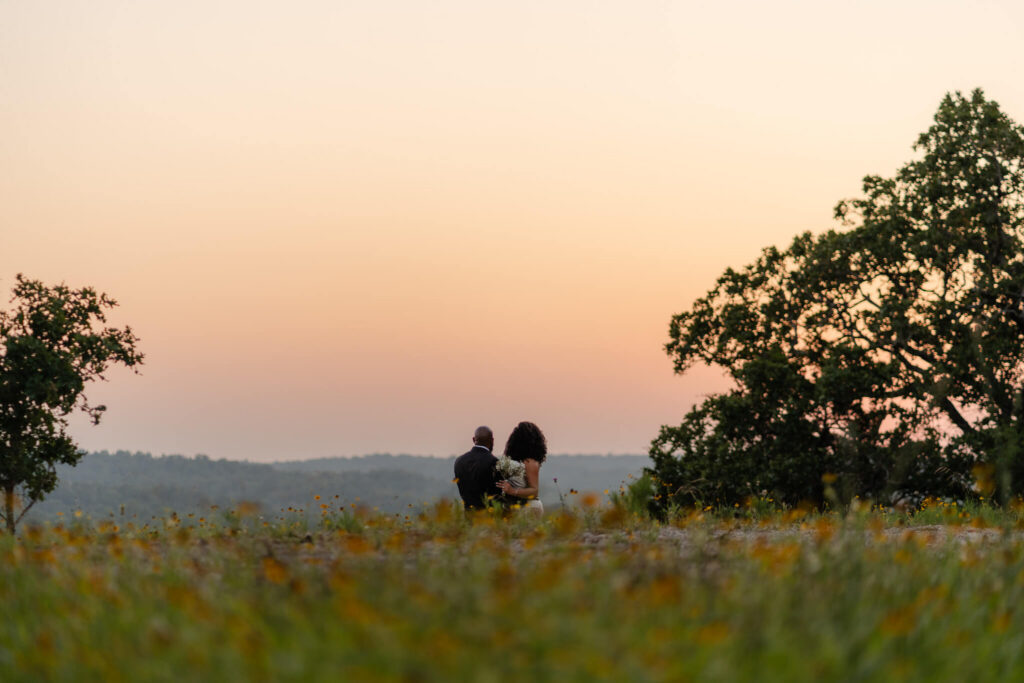 couple watches the sun set at an overlook in one of the best places to elope in Texas