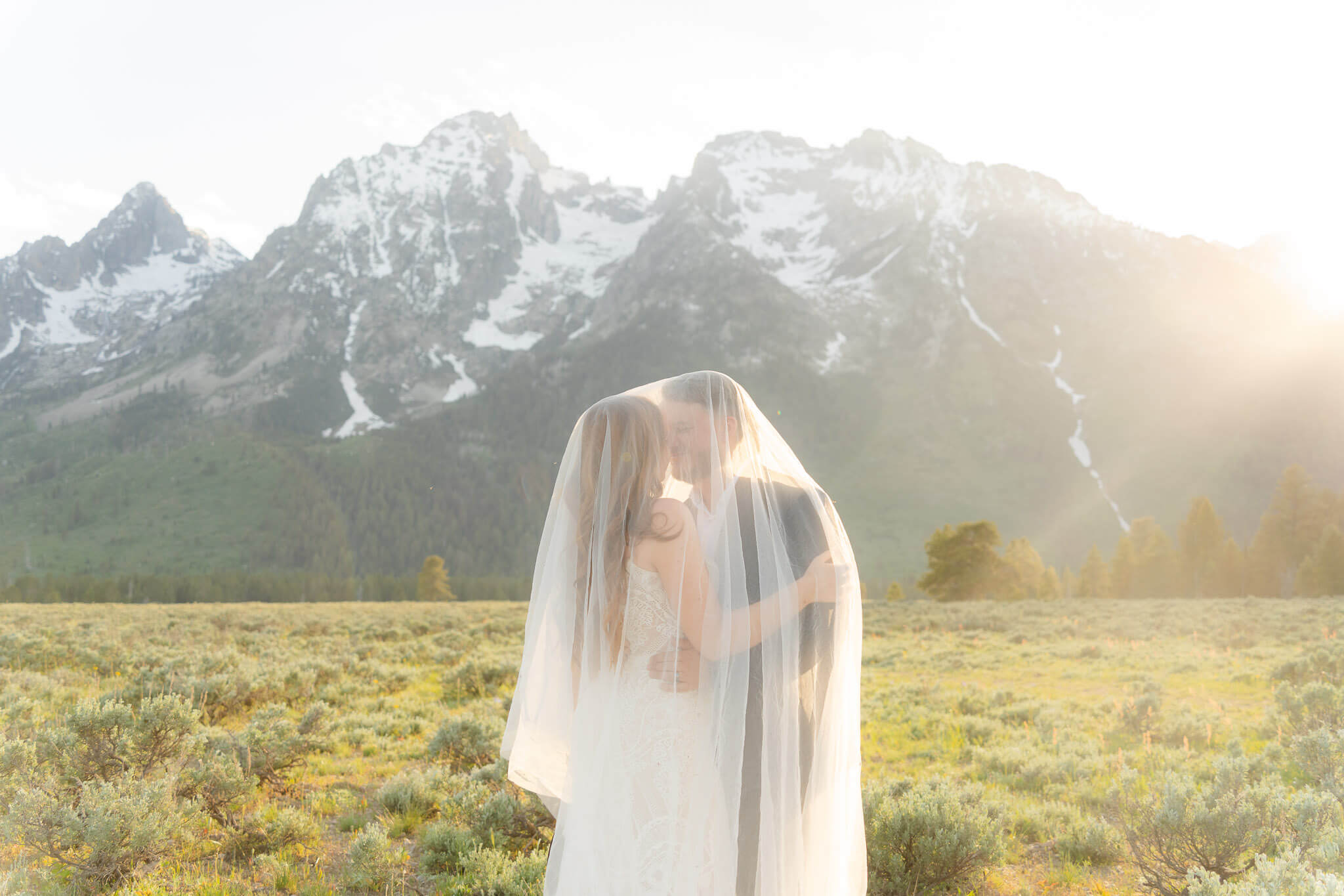 Couple shares a kiss in the sunlight during their Grand Teton elopement