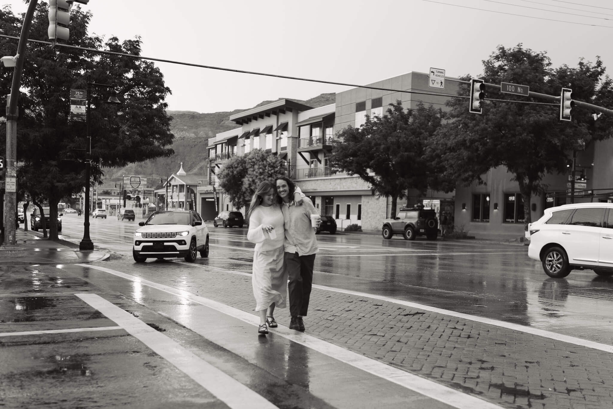 Couple joyfully walking through the rainy streets of Moab before their elopement