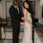 groom helps zip his brides dress up as they get ready for their enchanted rock elopement