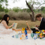 Picnic setup with cake and flowers at Enchanted Rock elopement campsite