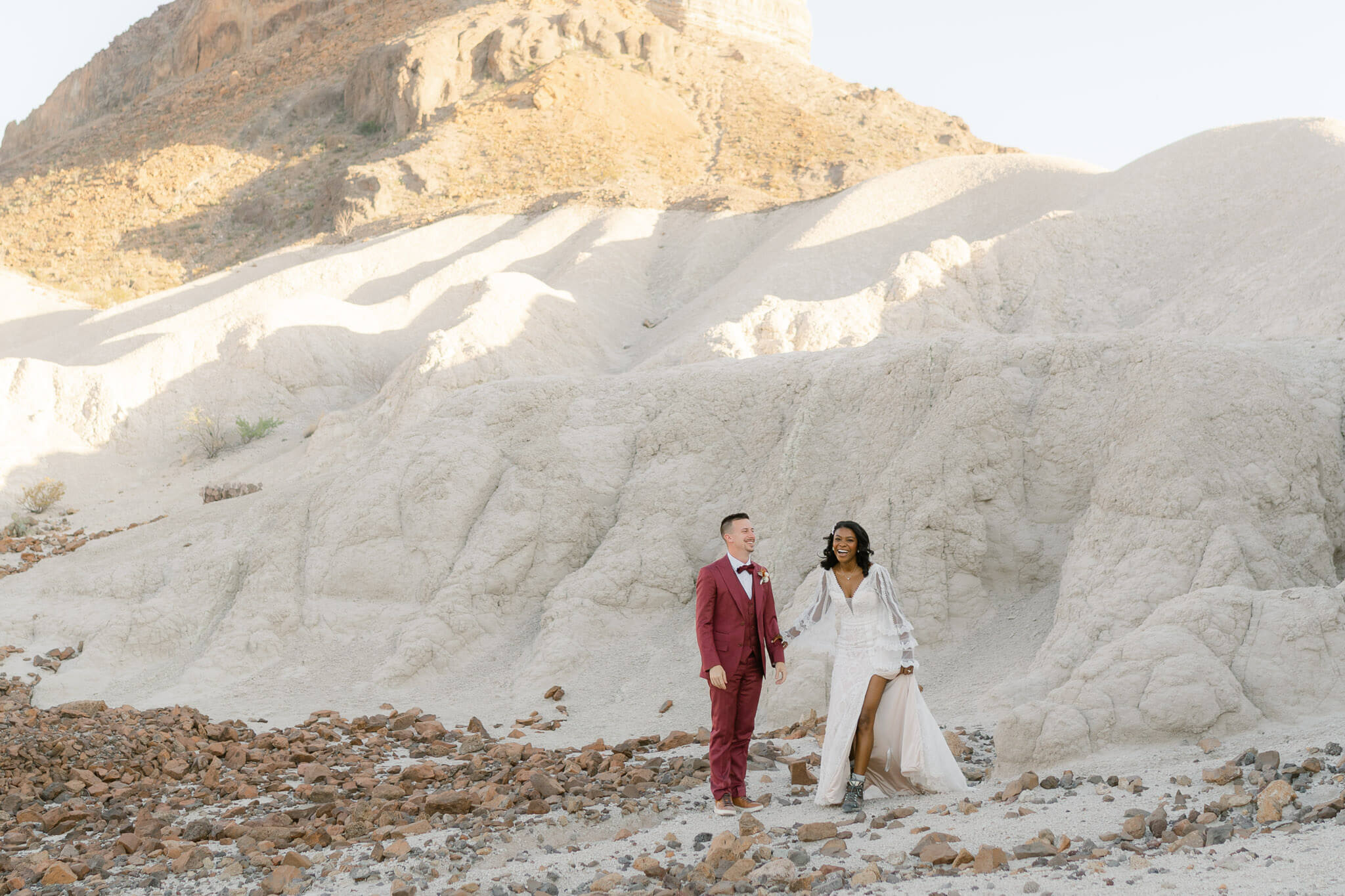 Couple laughs together after the groom helped his bride off of a rock while exploring during their elopement
