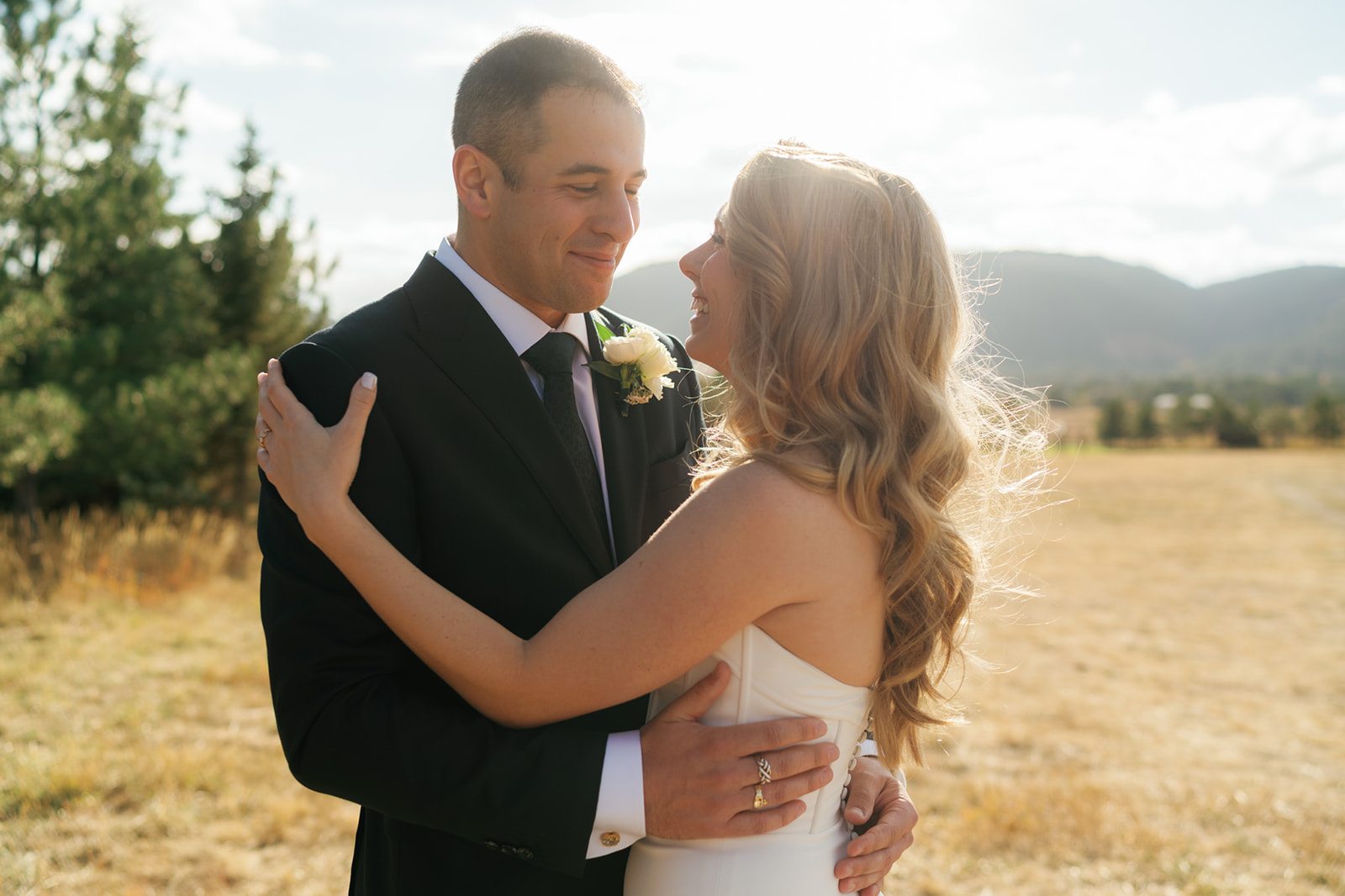 Newlyweds laugh and snuggle at sunset in a pasture when Eloping in Montana