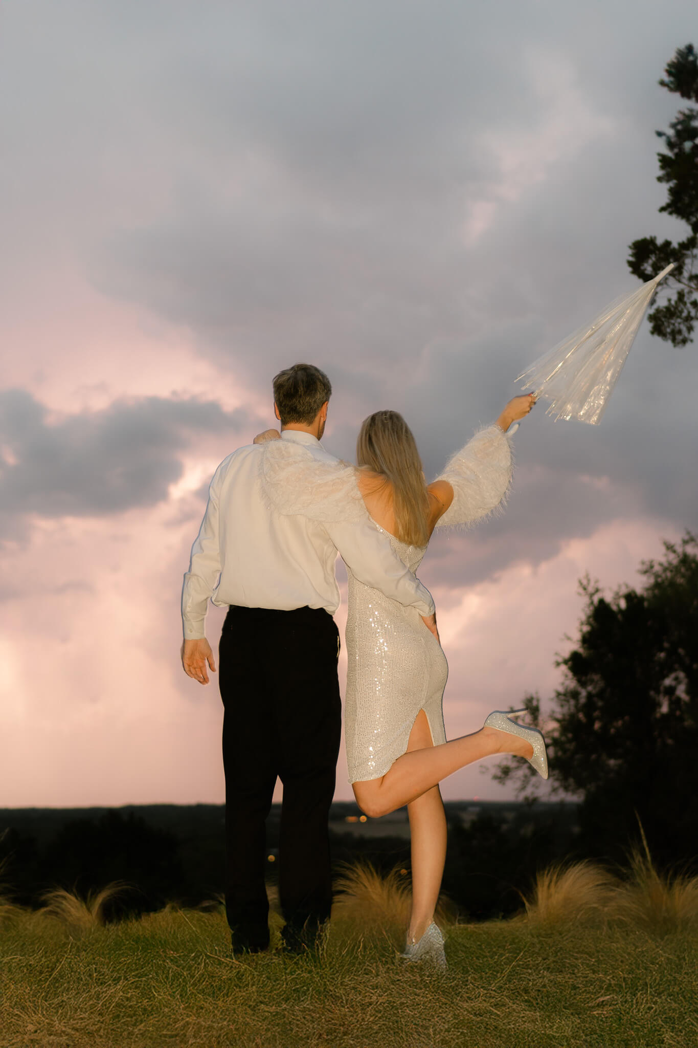 couple standing at an overlook as lightening strikes in the distance