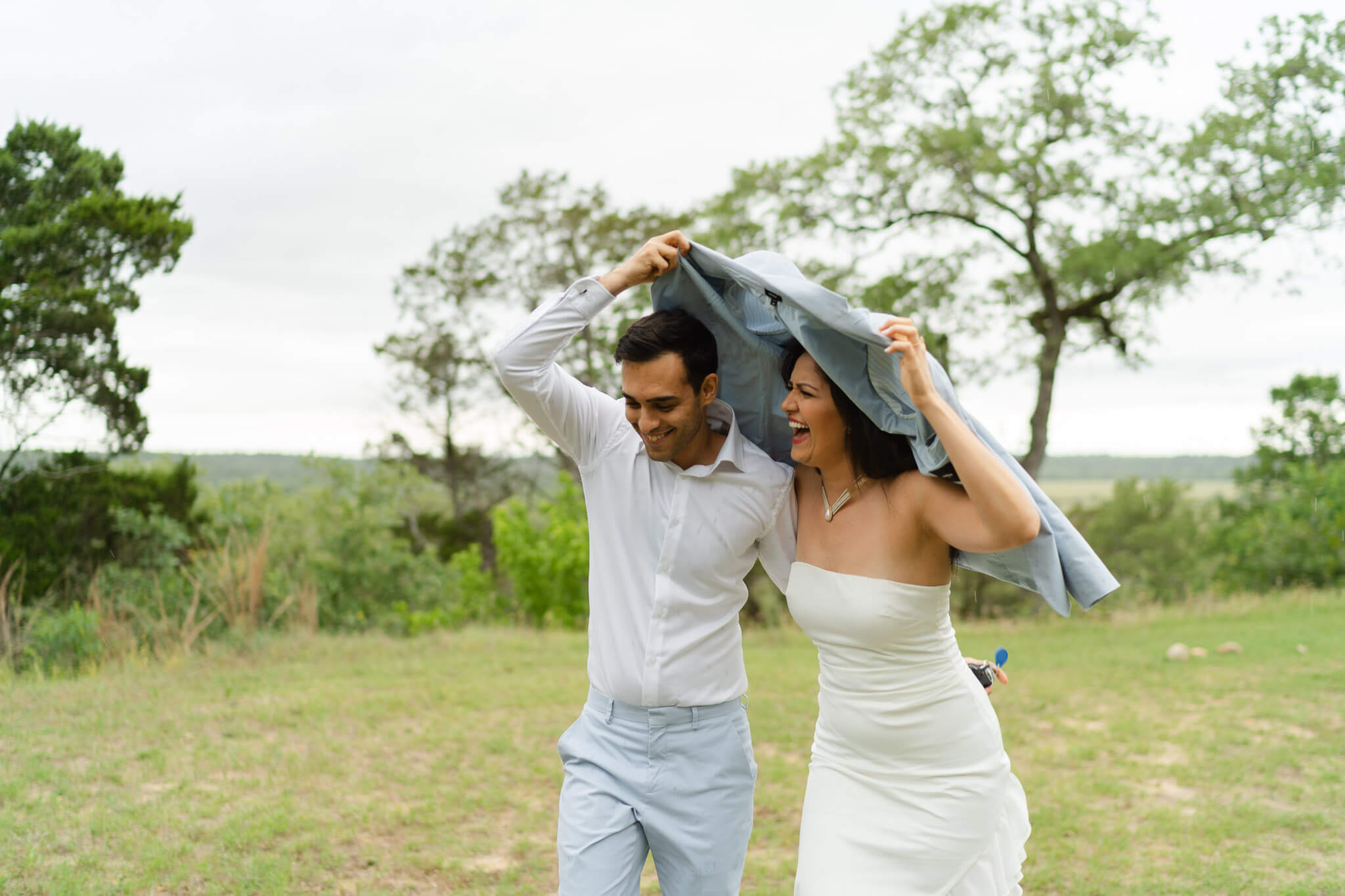 Couple runs through the rain at Austin elopement venue