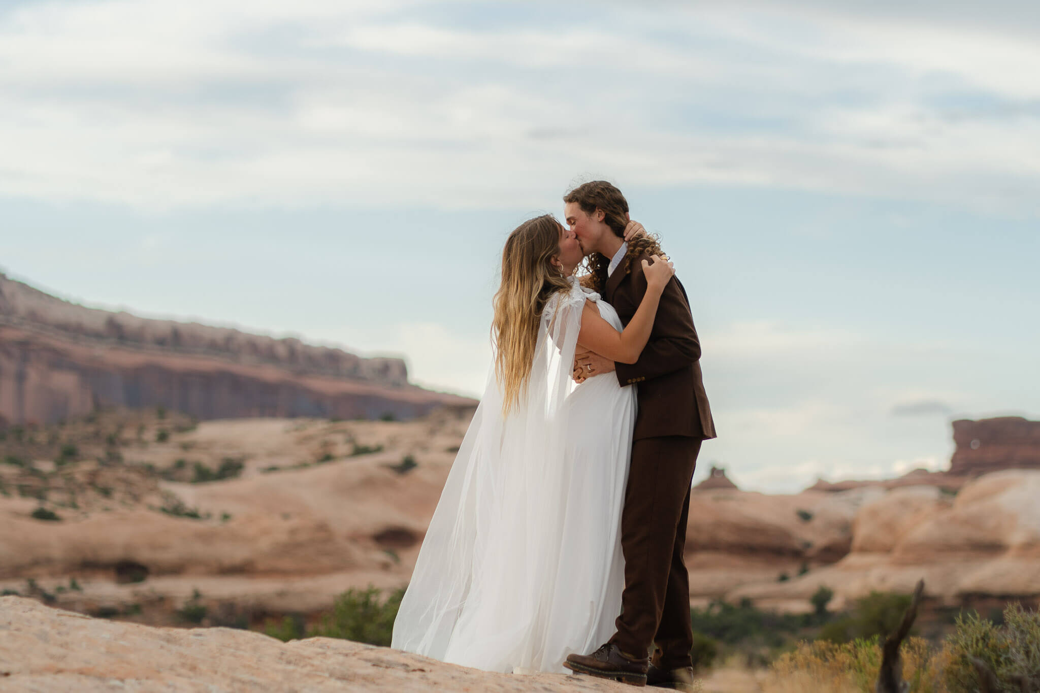 couple shares their first kiss in the Moab dessert