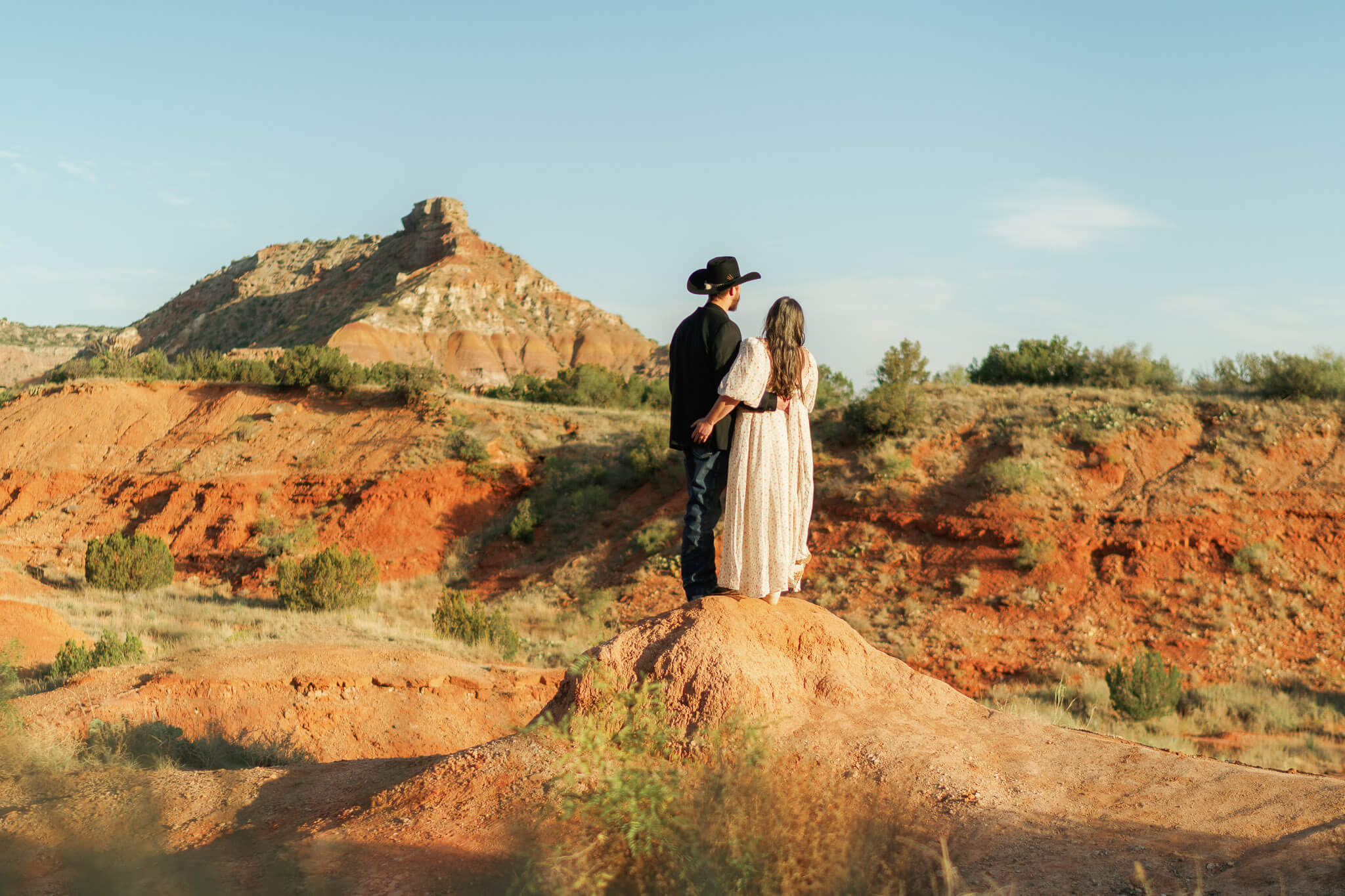 not every elopement outfit has to be official wedding attire, this couple stands atop rock formation in more casual wedding attire
