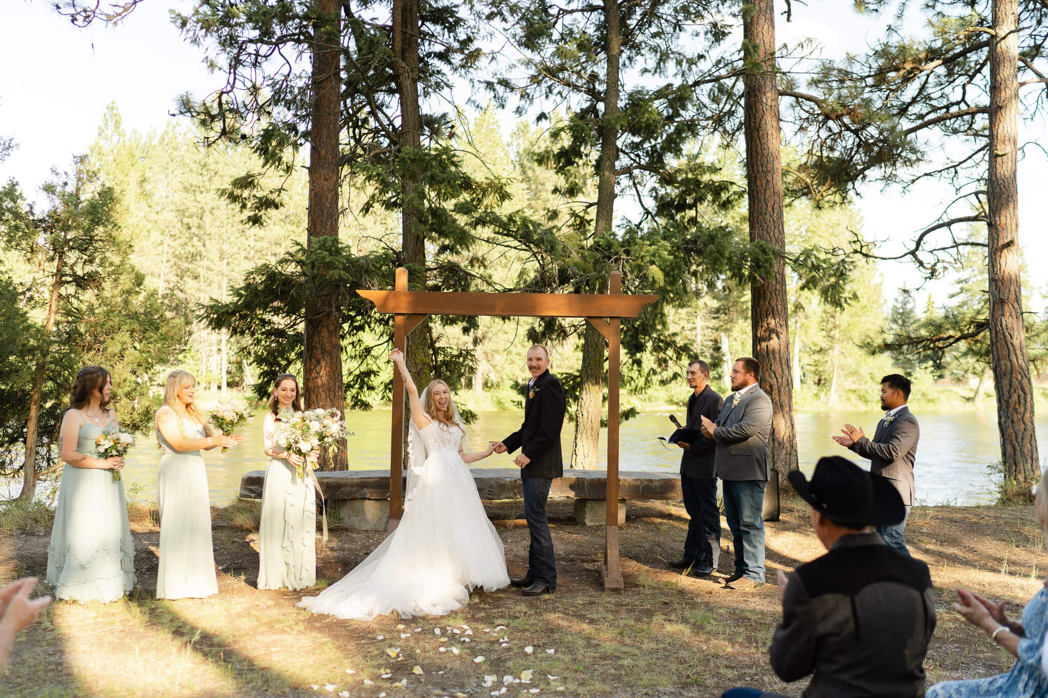 Bride and groom celebrating at the alter beside Swan River during their ceremony