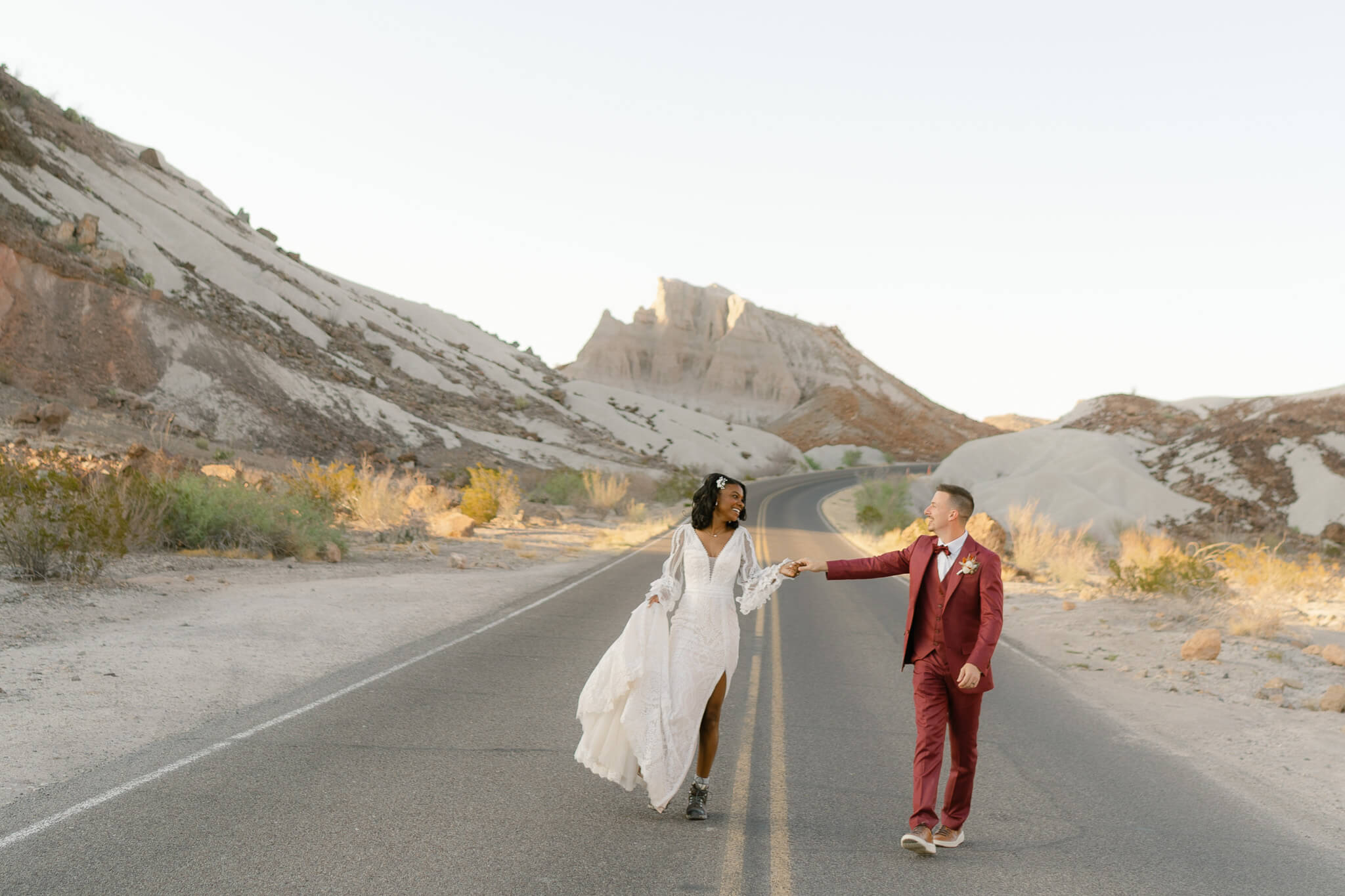 couple running down the desert mountain road outside of their Micro Wedding Venues in Utah