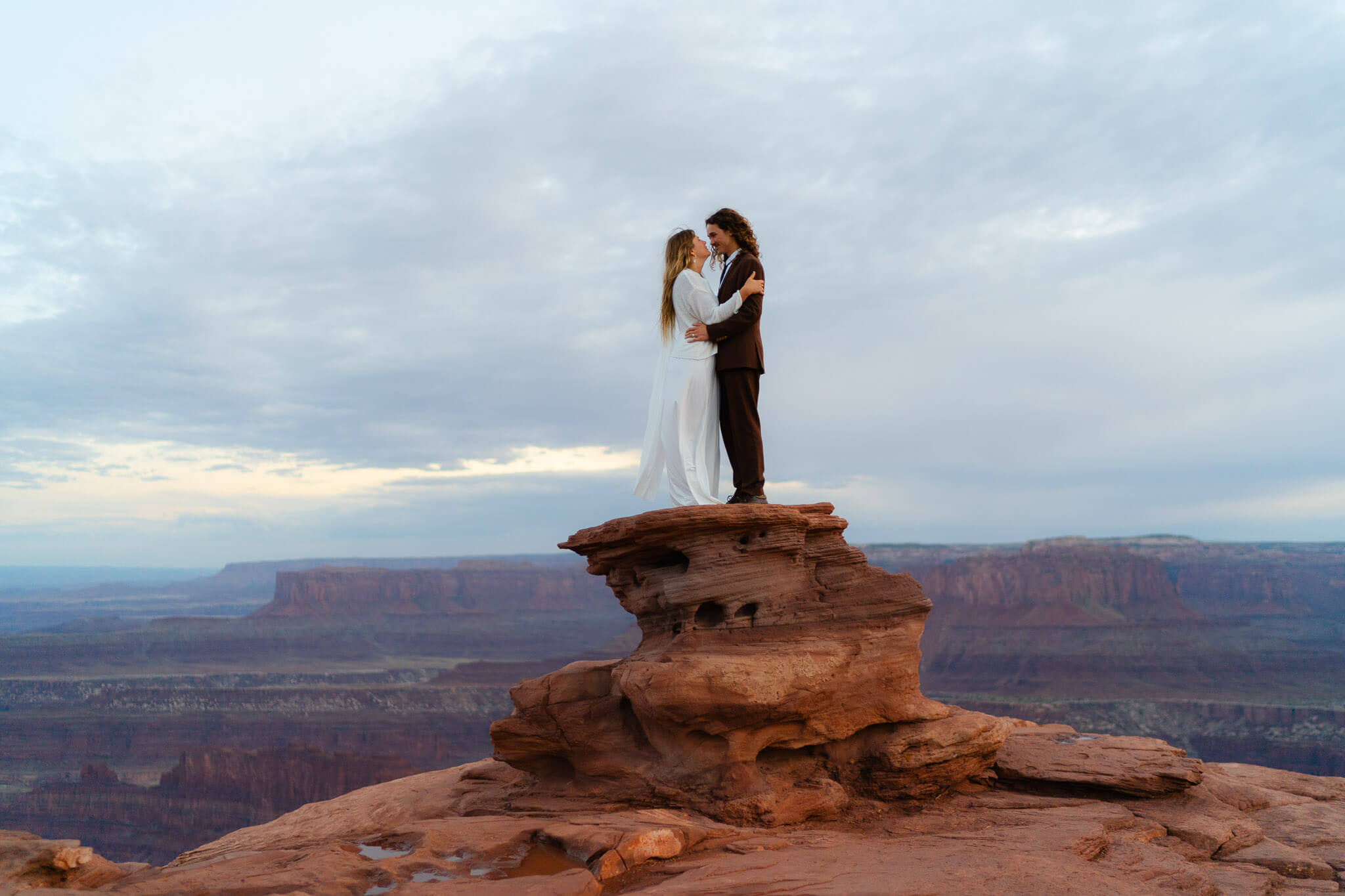 Couple standing on a rock formation at an epic Utah elopement locations