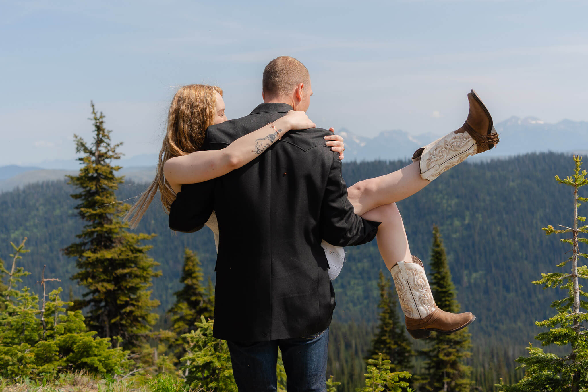 Groom spinning bride around on Big Mountain at Whitefish Mountain Resort wedding adventure session