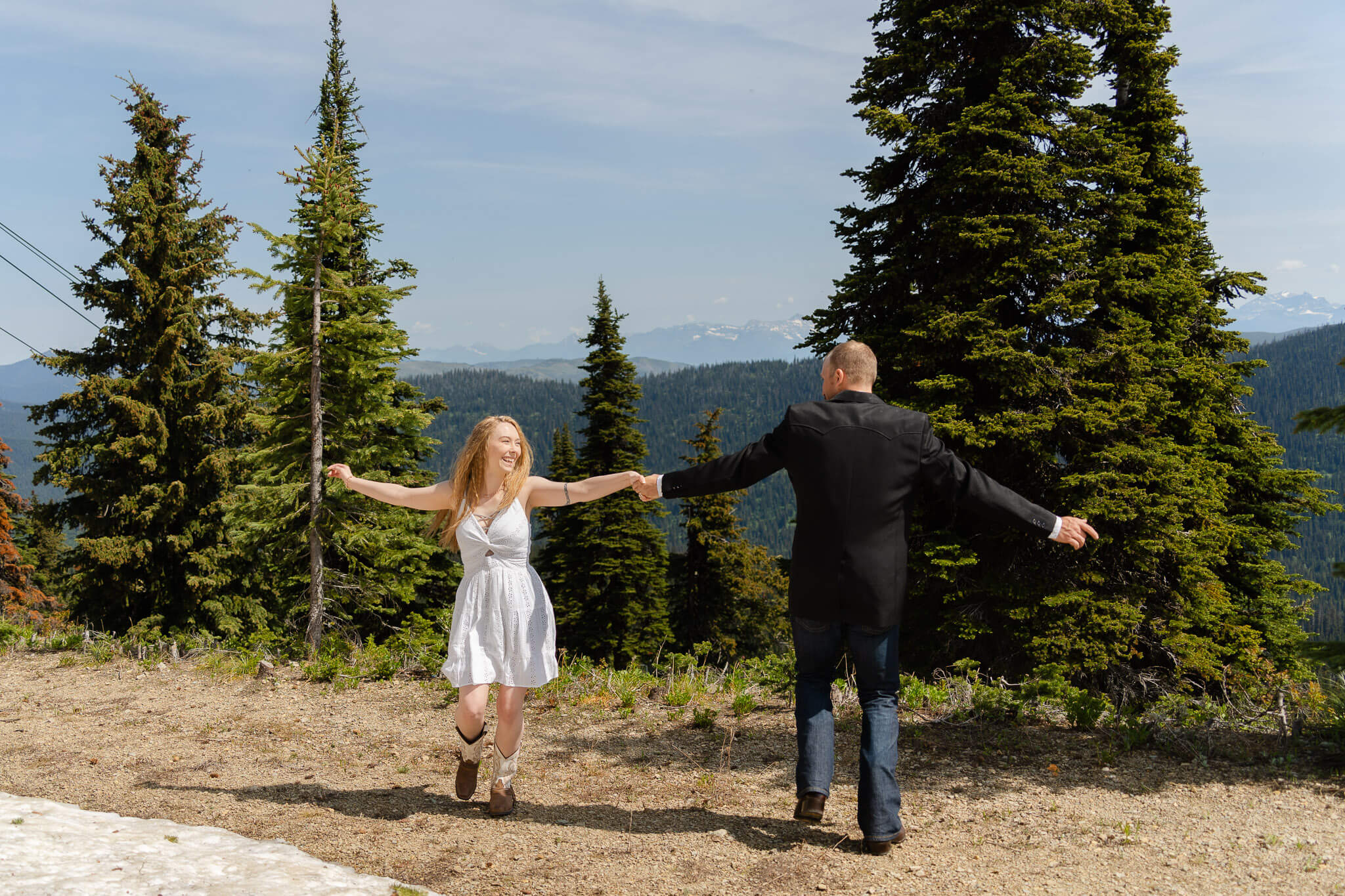 Couple spinning around joyfully on Big Mountain in Whitefish, Montana
