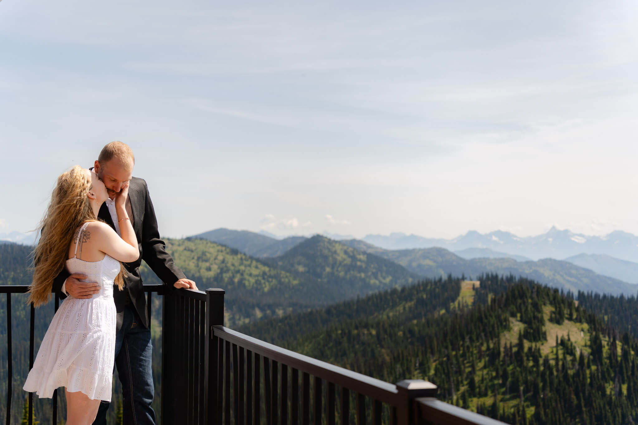 Bride and groom standing on back balcony on Big Mountain at Whitefish Mountain Resort wedding adventure session