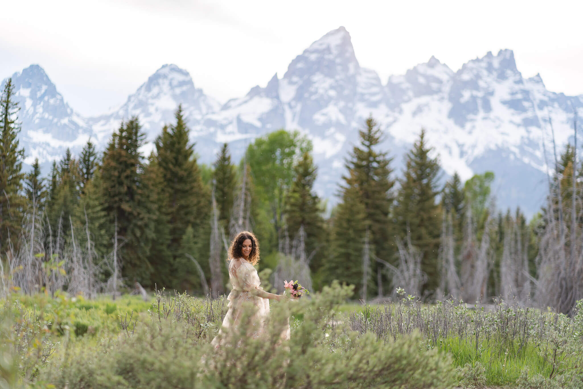 Wyoming elopement bride walks through a trail