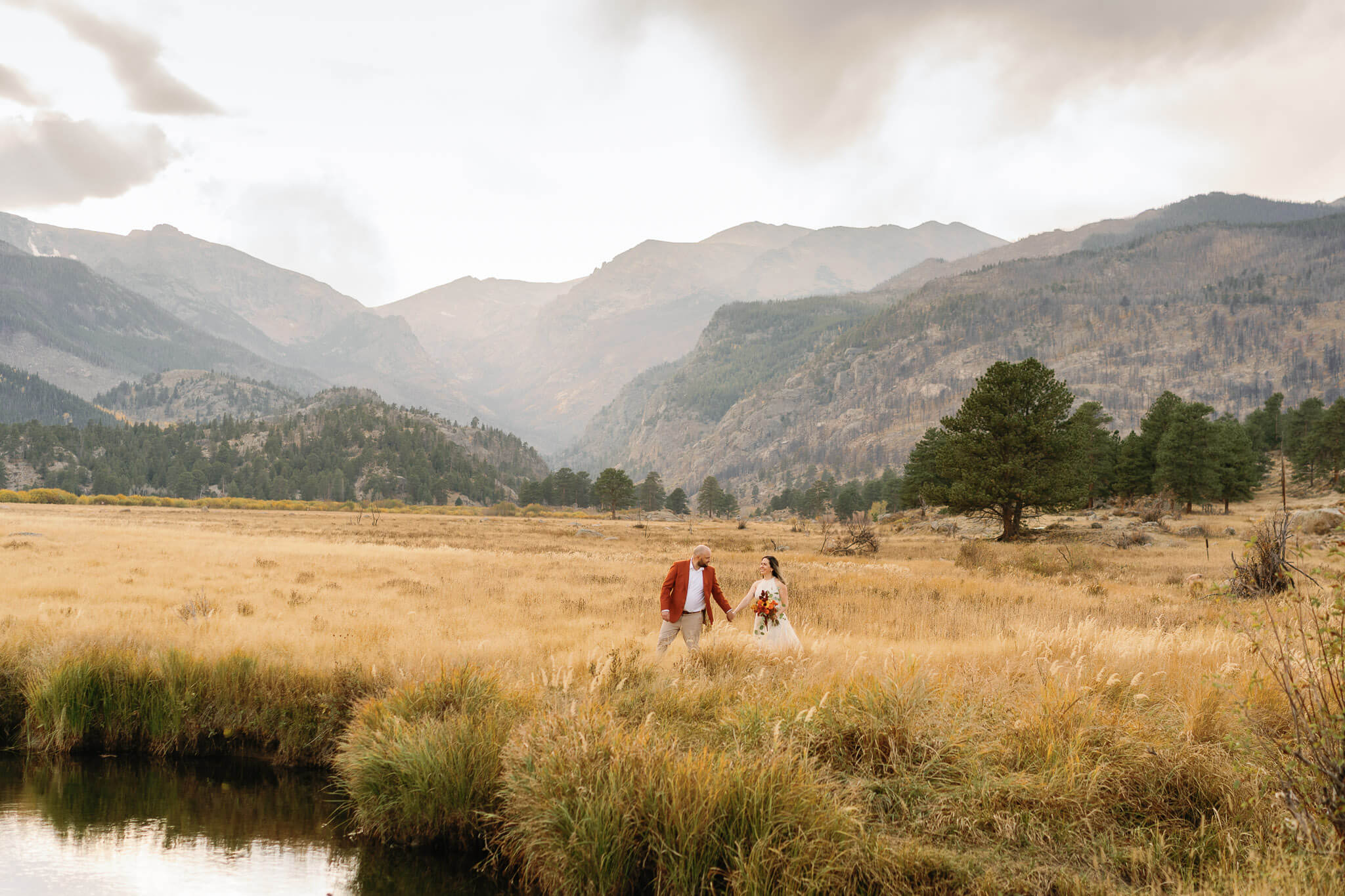 Couple walking along a trail in the fall grass in RMNP one of the best places to elope in the US in the fall