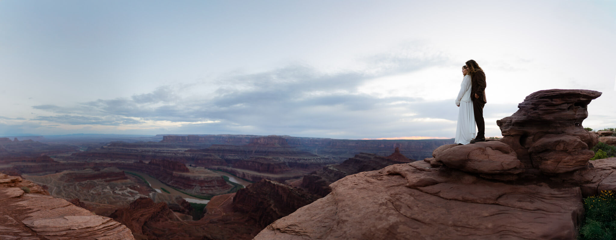 Couple overlooking Deadhorse Point enjoing the sunset as blue hour creeps in after they elope in Utah