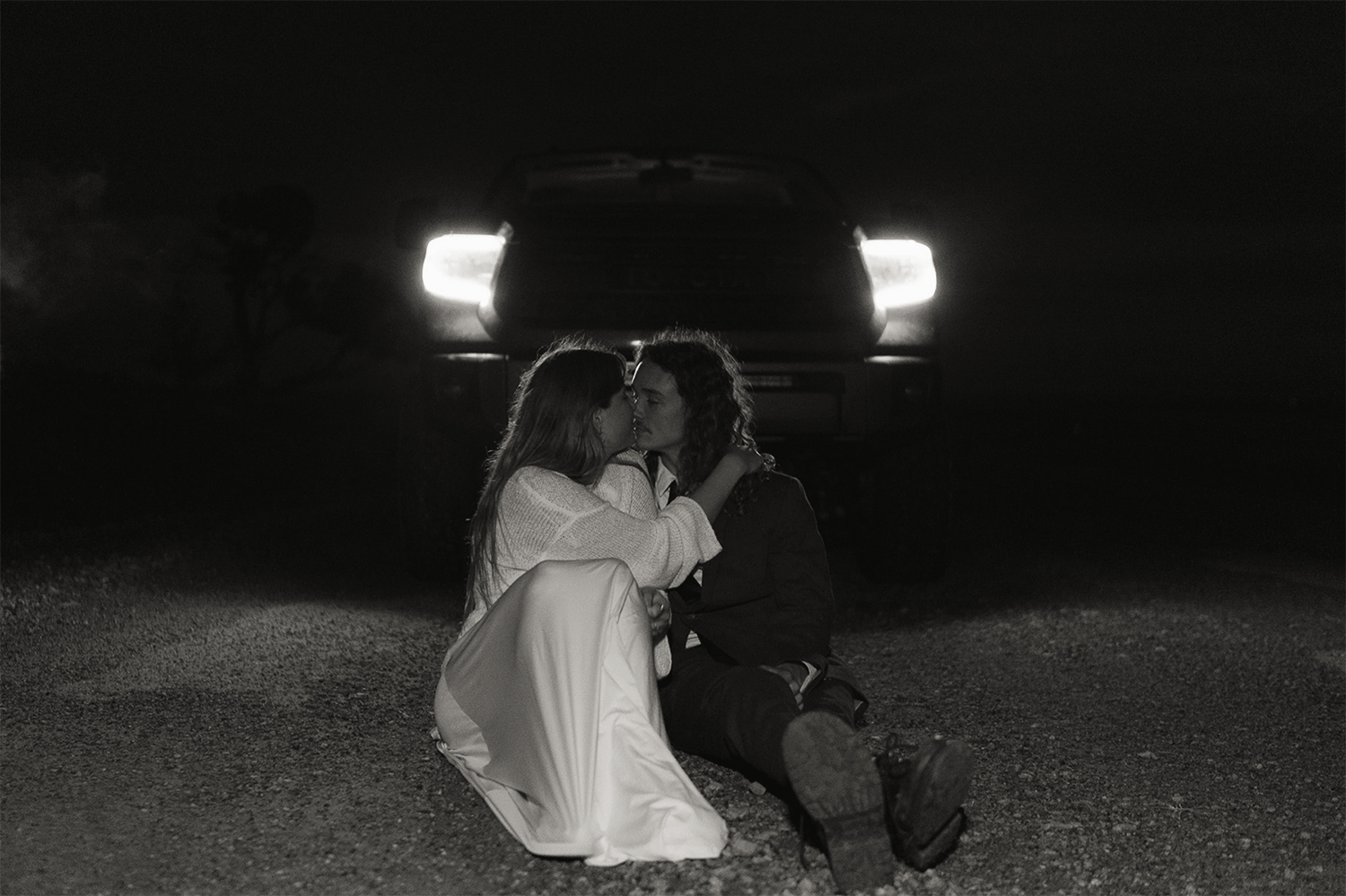Couple shares a quiet moment after they elope in Utah in the headlights as fog blows around them