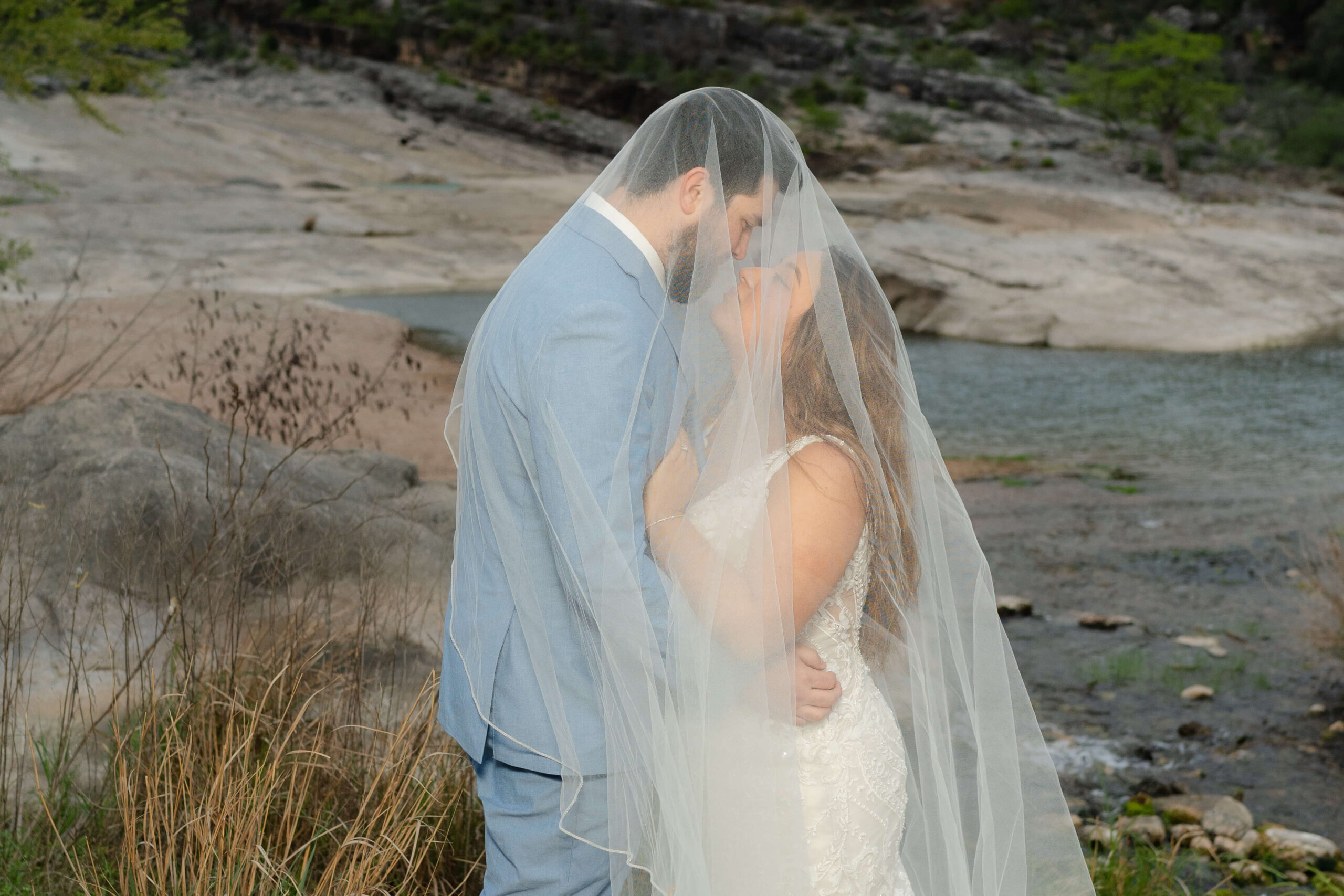 Couple standing under the bride's veil at a scenic Texas Hill Country elopement destination