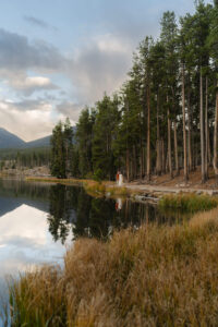 couple in the distance at a lake at sunset after they chose to elope in Colorado