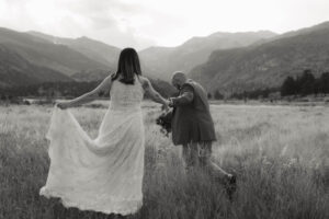 groom help his bride through the grass