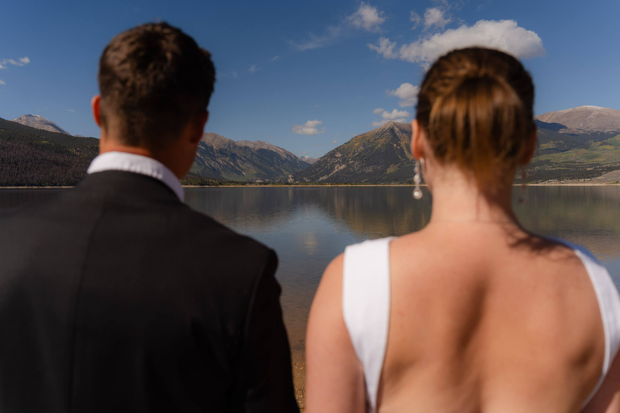 Couple standing together looking off to the mountains after their Twin lakes elopement