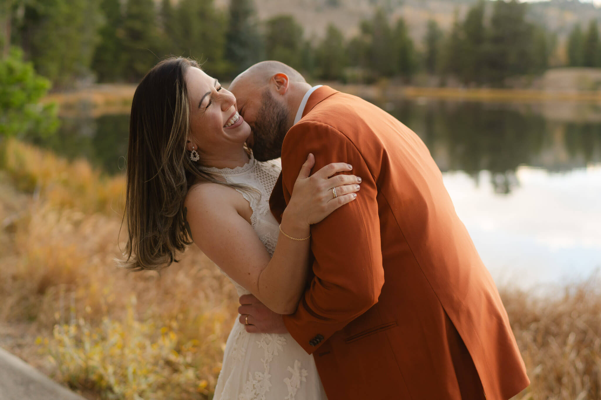 Bride and groom laughing and kissing after their twin lakes elopement