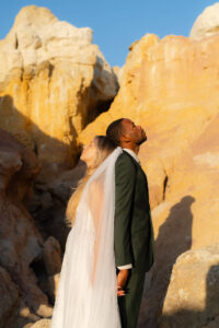 bride and groom standing back to back as the warm sunshine touches their faces before they elope in Colorado