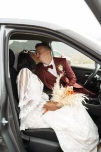 couple kisses in their car before heading out