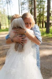 mom hugs her daughter before their wedding ceremony with family on their two day elopement