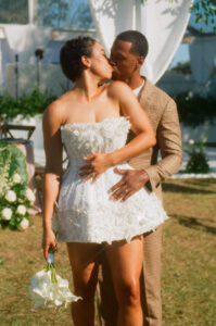 Couple at a Havana Nights inspired wedding, with the bride in a shimmering short dress that catches the light, photographed on nostalgic 35mm film for green wedding inspiration.