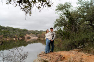 couple overlooking a lake at their Hill Country Engagement photos